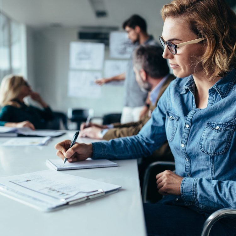 Young,Businesswoman,Sitting,In,The,Office,With,Businessman,Presenting,In